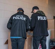 Police officers go through a list of property seized from internal theft ring