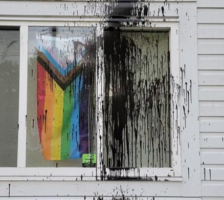 Ladner United Church Progress Flag with paint splashed on window in front of it